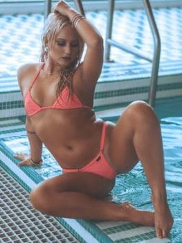 Model wearing a coral bikini beside a pool